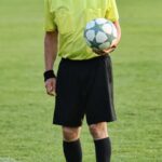 Un Arbitro con il pallone in mano
