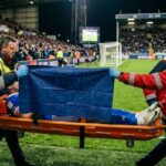 Un calciatore infortunato esce in barella - immagine generata con AI