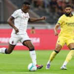SEPTEMBER 14: Jhon Lucumi of Bologna controls the ball whilst under pressure from Ruben Loftus-Cheek of AC Milan during the Serie A match between AC Milan and Bologna FC 1909 at Giuseppe Meazza Stadium on September 14, 2025 in Milan, Italy.
