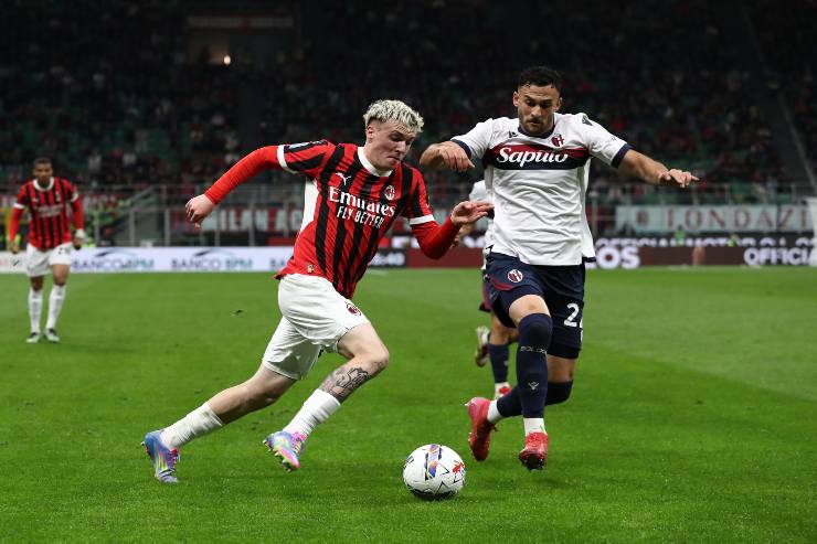 MILAN, ITALY - MAY 09: Alex Jimenez of AC Milan runs with the ball whilst under pressure from Charalampos Lykogiannis of Bologna during the Serie A match between AC Milan and Bologna at Stadio Giuseppe Meazza on May 09, 2025 in Milan, Italy.
