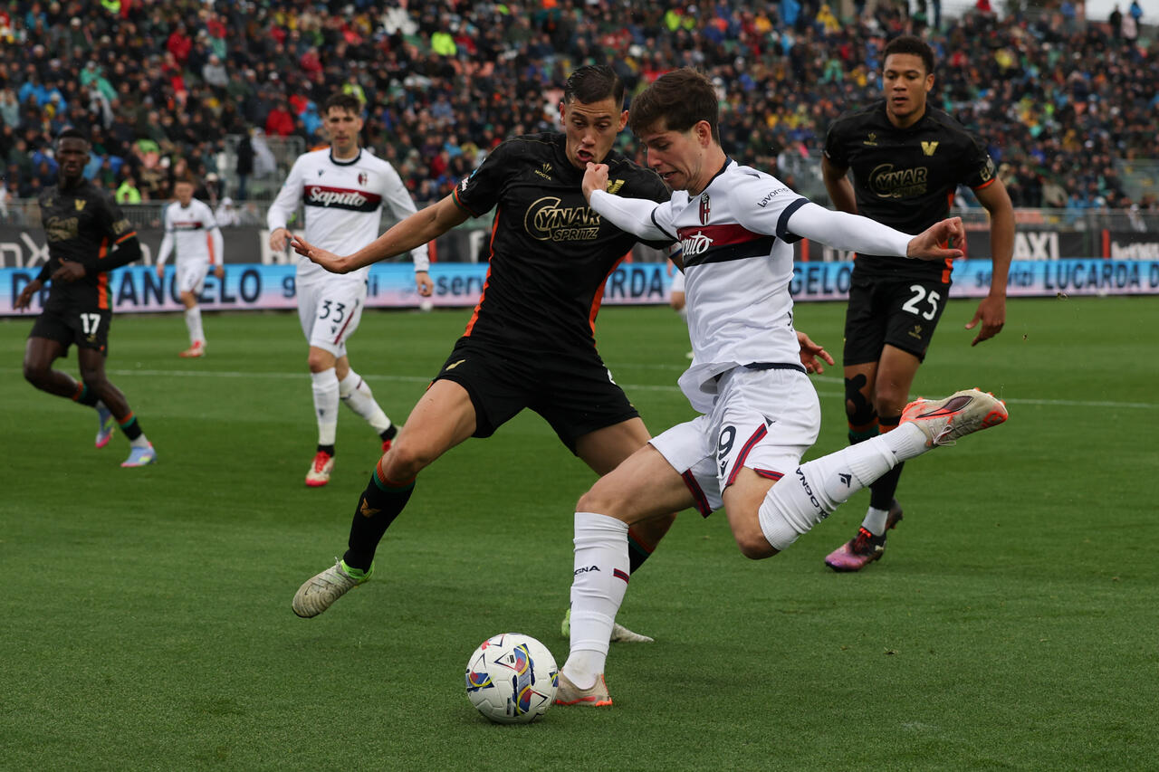 Estanis Pedrola del Bologna effettua un cross sotto pressione da parte di Jay Idzes del Venezia durante la partita di Serie A tra Venezia e Bologna allo Stadio Pier Luigi Penzo